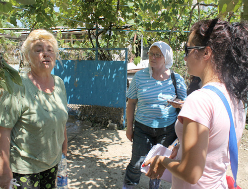 Краснодарский край, Крымск, 9 июля 2012 г. Волонтер беседует с местными жителями. Фото Никиты Серебрянникова для "Кавказского узла"