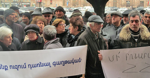 Акция бывших сотрудников завода "Наирит". Надписи на транспарантах: «Мы не хотим стать эмигрантами» (слева), «Не терзайте законы Республики Армении!» (справа). Ереван, 5 марта 2015 г. Фото Тиграна Петросяна для "Кавказского узла"