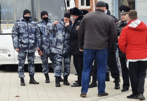 Люди в штатском общаются с ОМОНовцами во время акции протеста в Краснодаре. Впоследствии один из них (в красной куртке справа) помогает полицейским задерживать участника акции и силой помещать его в автобус. Краснодар, 31 января 2021 года. Фото Анны Грицевич для "Кавказского узла".